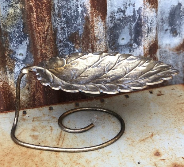 Vacker bladformad skål på fot i guld. Detaljrik och lätt ruffig i ytan . För förvaring och dekoration. Finns i två storlekar -Hö