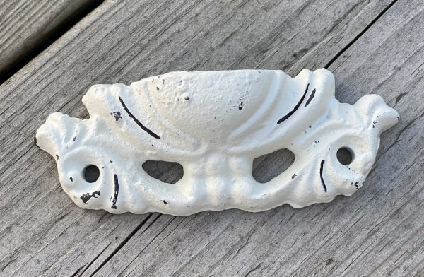 Vitt handtag i järn. Skålformad modell med vacker dekor. Fabriks sliten med skavd dekor. Designad efter i en gammeldags vacker m