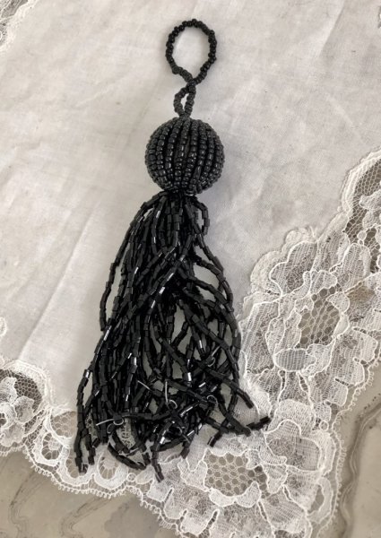 Vacker svart tassel / tofs dekoration med pärlor och ögla upptill. Att dekorera med hänga på en glaskupa, en dörr, lägga på ett