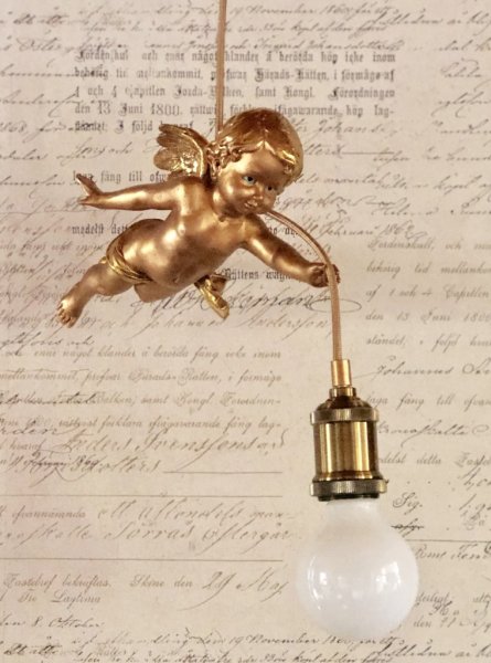 Vacker och annorlunda ängel lampa i hängande modell. Går i en mjuk nyans av guld och antikguld på ett antikt och gammeldags vis.