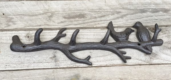 Detaljrik och annorlunda hängare formad som ett träd dekorerad med två fåglar. Tillverkad i järn och går i en brun nyans. Grenar