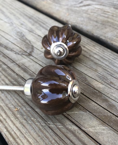 Blomformad brun porslinsknopp med silver färgad krage. Knoppen har en blankare yta. Mäter Längd: ca 7cm Bredd: ca 4cm Säljes