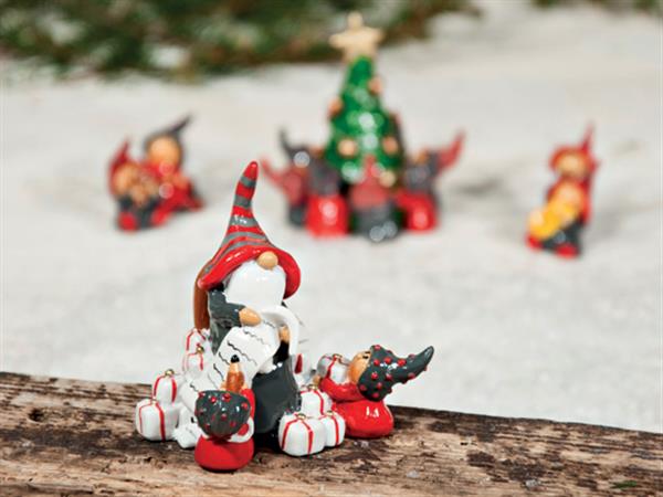 Tomte med önskelista omgiven av sina nissar och massor av paket. Välarbetad och detalj full i fin modell. Höjd: 7,5cm Bredd: ca