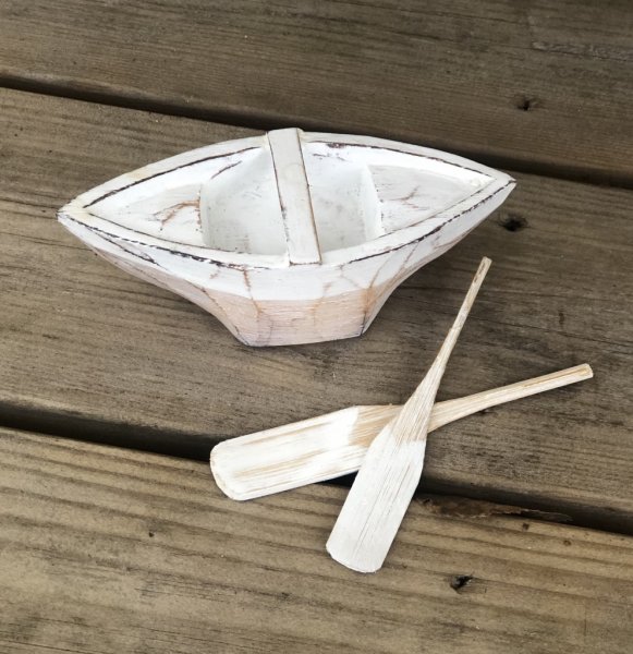 Liten båt med åror i trä. Marin drivveds dekoration. Gammaldags designad med fabriks slitna inslag i den målade ytan. Att dekor