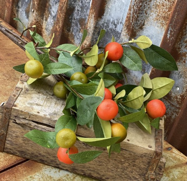 Vacker kvist / gren med apelsiner och gröna blad. Konstgjord modell med hög verklighetstrogen känsla. Att dekorera med välarbeta