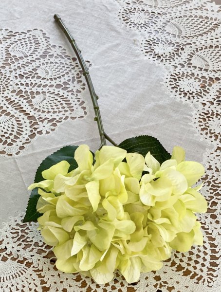 Utslagen hortensia i ljus gröna nyanser med gröna blad. Välarbetad och verklighetstrogen konstblomma. I kvist/gren modell om en