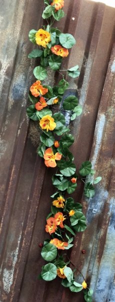 Vacker blomstergirlang/slinga med krasse. Färgstarka blommor i gult och orange samt frodiga täta gröna blad. Välarbetad och verk