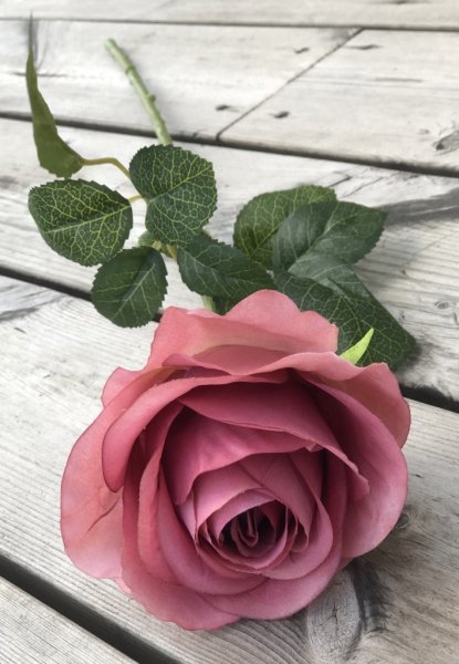 Vacker ros i större modell med gröna blad och en mjuk nyans av gammelrosa. Välarbetad och verklighetstrogen konstgjord modell.