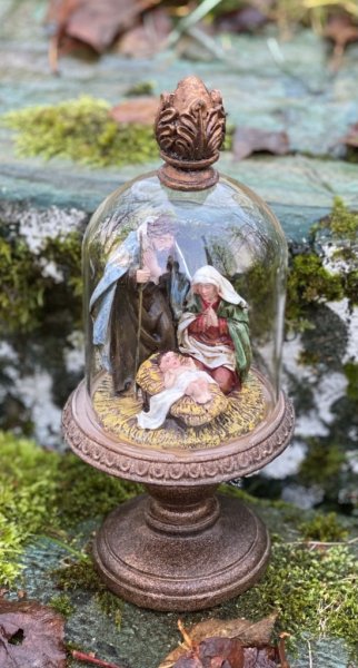 Vacker julkrubba med Josef, Maria och Jesus barnet. Under en glaskupa som står på ett vackert dekorerat fat på fot. Kupan sitter