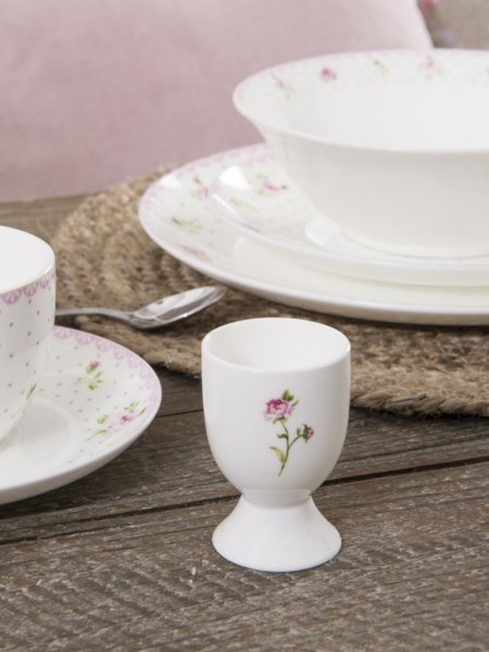 Vit äggkopp i porslin dekorerad med rosor i lantlig romantisk stil. äggkoppen är i klassisk modell med fot nertill. Mäter ca c