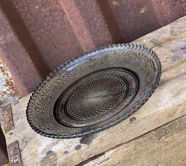 Vacker grå assiett i glas. Med vågad kant runt om och fint mönster i glaset. Mäter 14,5cm Säljes per styck en och en