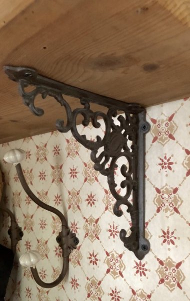 Konsol till tex hylla i smide mörk antik brun med detaljrikt utformning. Passar lika bra inne som ute. Höjd: ca 19,5 cm Dju