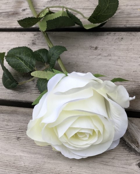 Vacker ros i större modell med gröna blad och en mjuk vit/cream vit nyans. Välarbetad och verklighetstrogen konstgjord modell.