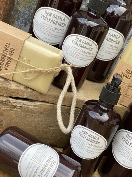 Den gamla tvålfabriken produkter i gammeldags design med stor klassisk bit tvål på snöre. Tvål och handkräm i pump förpackning.
