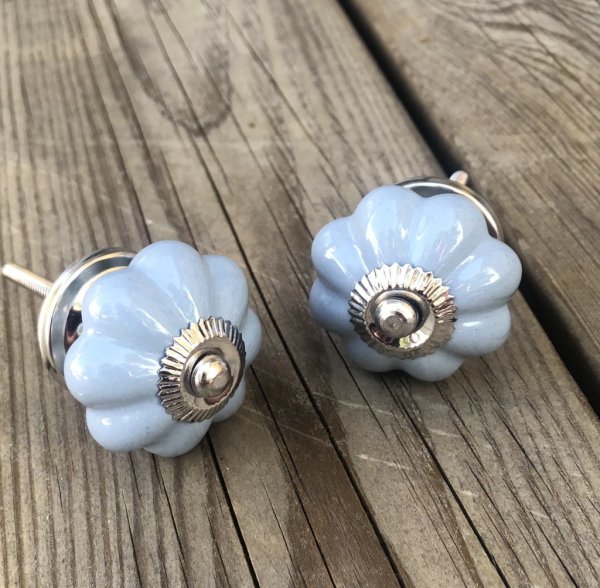 Blomformad porslinsknopp lätt cream vit med krage i silver. Mäter Längd 8cm Bredd ca4,4cm Säljes per styck en och en