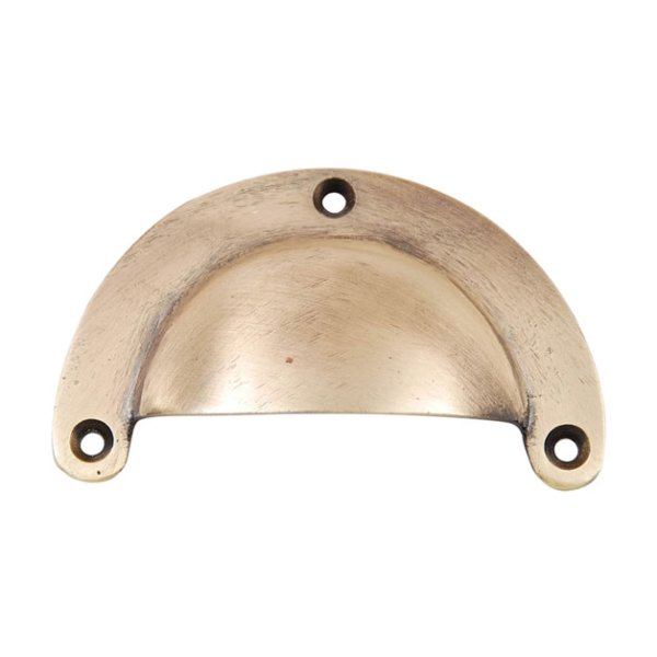Skålformat handtag i metall. Går i en guld färgad nyans. Handtaget kan sättas med öppningen uppåt och nedåt. Mäter 9,5*5,5*2cm