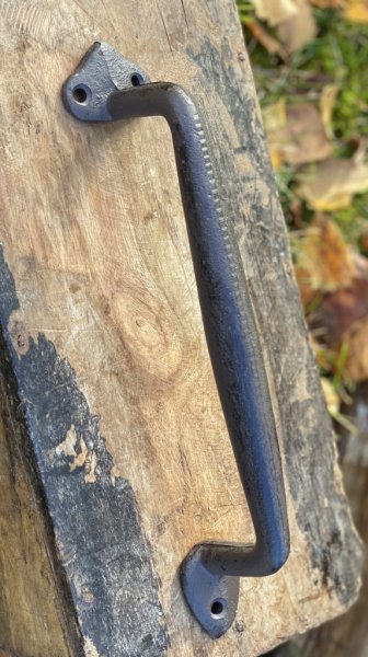 Stort dekorerat handtag i järn. Mörk brunt i nyansen med bra grepp yta för handen. Tyngre i modellen. Passande inomhus som utomh