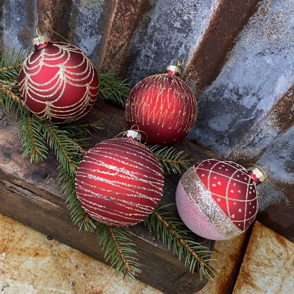Julgranskulor / glaskulor i rött med vackra guld glittrande mönster inslag. I pack om 4st kulor med olika mönster . Eleganta med