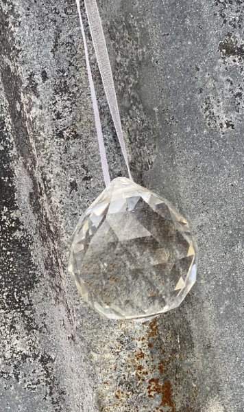 Vackert dekorerad rund bollformad glas prisma. Med fina slipningar runt om som reflekterar vackert i solljus. Band upptill att