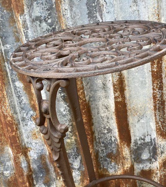 Vackert snirkligt dekorerad pedistal / sidebord i järn. Går i en antik stil och design och en nyans av ruffigt brunt. För blommo
