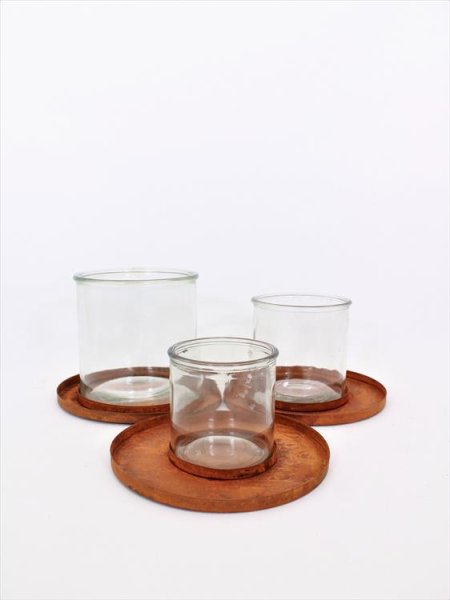 Ljuslykta till lika kruka i glas och rost. Ljusglas/kruka i kraftigt glas som står på en rund bricka i rost. Att ha som den är e