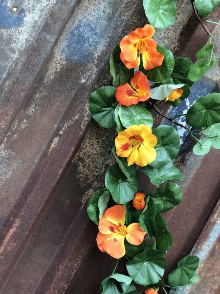 Vacker blomstergirlang/slinga med krasse. Färgstarka blommor i gult och orange samt frodiga täta gröna blad. Välarbetad och verk