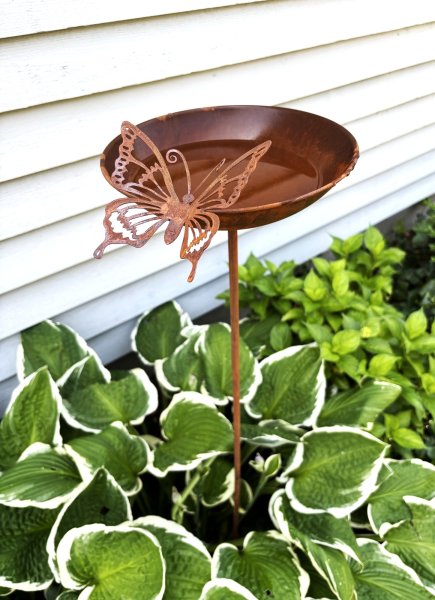 Fågelbad på pinne i rost med fjäril