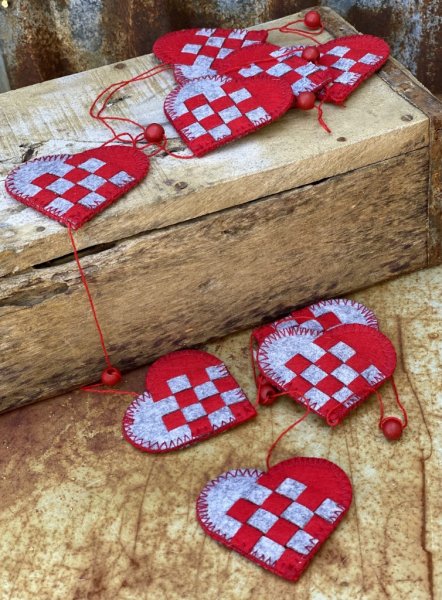 Girlang med hjärtan och pärlor i rött och grått. Designad i gammaldags stil tillverkad i filt och textil. Att hänga och dekorera
