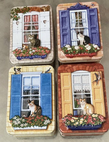 Vacker plåtburk/ask med 3D motiv av en katt i ett fönster på ett hus. Där huset är burken/asken. Finns i fyra olika modeller -Vi