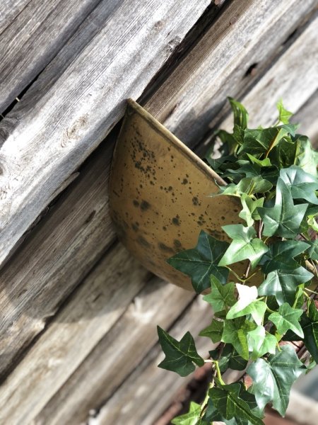 Viola väggkruka i antik modell, tillverkad i plåt och går i en lätt ruffig nyans av antik guld . Oval båt formad i modellen med