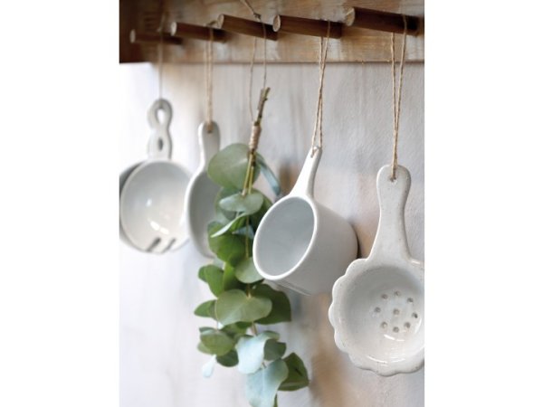 Sked / skopa i porslin. Lika vacker som praktisk med snöre upptill så man kan ha den hängandes. Går i en mjuk ljusgrå nyans. Pas