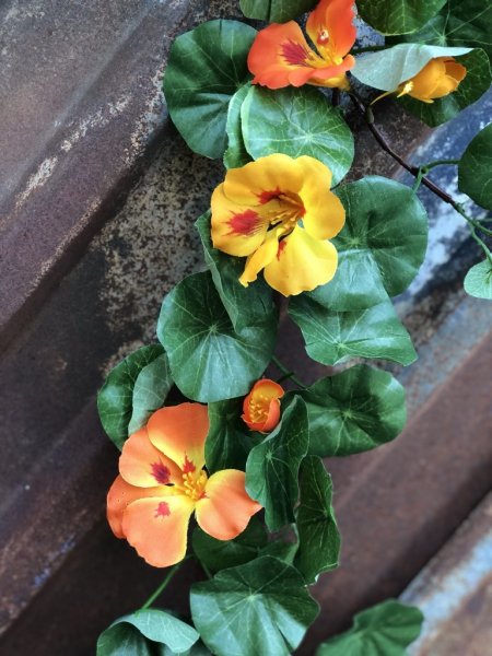 Vacker blomstergirlang/slinga med krasse. Färgstarka blommor i gult och orange samt frodiga täta gröna blad. Välarbetad och verk