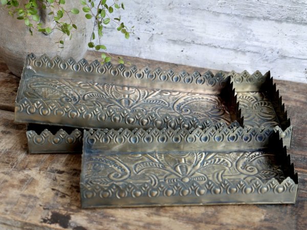 Vacker och elegant bricka till lika ljusfat i avlång modell. Tillverkat i plåt/metall och går i en antik guld färgad nyans. Stil