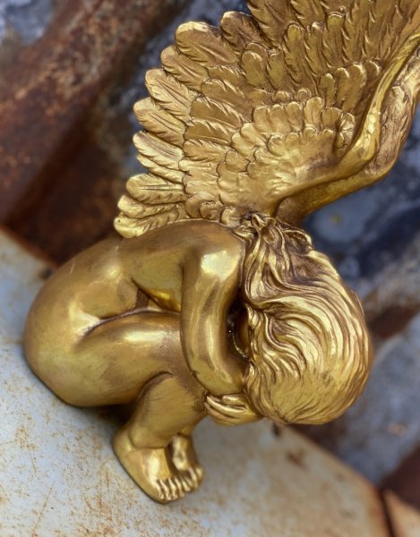 Vacker elegant och stilfull guld färgad sittande ängel. Med detalj fulla långa vingar och nedböjt huvud. Att dekorera med. Höjd