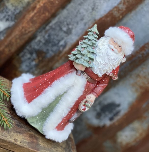 Vacker röd tomte/ jultomte med mjuka inslag av grönt och vitt. Tomten har en glittrande gran i handen och päls kantad kappa samt