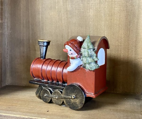 Tåg / lok med snögubbe och julgran. I vacker välarbetad modell med söta detaljer runt om. Går i mjuka jul nyanser och granen har