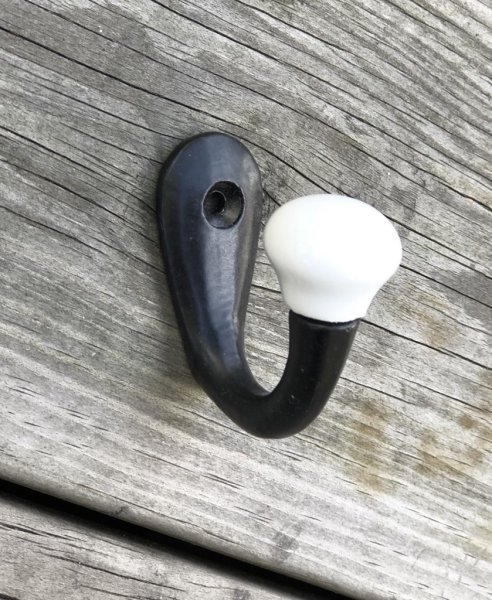 Krok / hängare i gammeldags industri stil . Svart lätt fabriks sliten i ytan med vit porslins knopp. I enkel modell. Från Madam