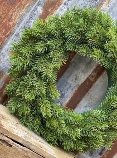 Vacker dörr/vägg krans av granris. Konstgjord, välarbetad och verklighetstrogen. Kransen är byggd på grön frigolitbas som inte s