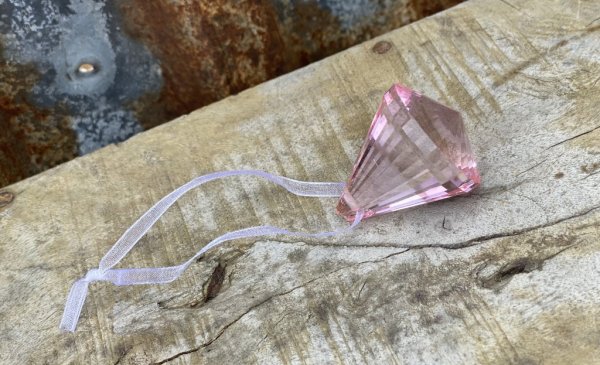 Vackert droppformad prisma i rosa glas. Slät modell som reflekterar vackert i solljus. Band upptill att hänga prisman i, lika va
