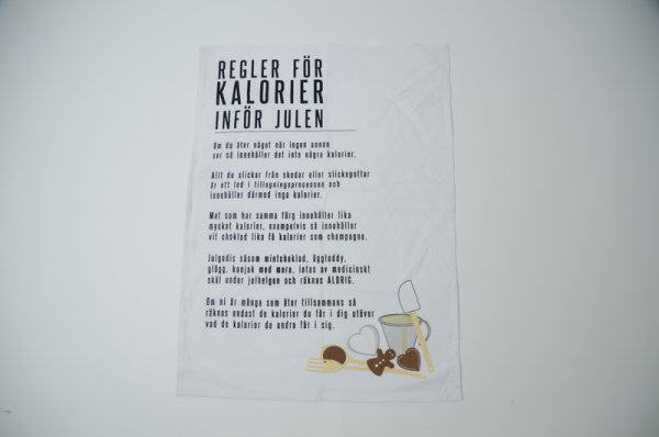 Rolig köks handduk med text  Regler för kalorier inför julen . På vit bas med svart text . Med öggla för upphängning i sidan upp