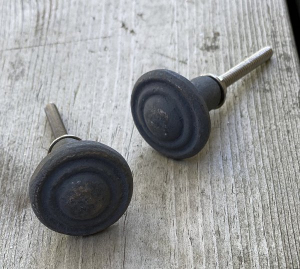 Svart knopp i järn. Ruffig yta rund i modellen med diskret mönster. Mäter 7*3cm