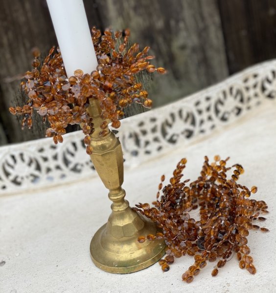 Ljusmanschett /servettring med bruna pärlor. Pärlorna är trädda på elastisk tråd och kan därav anpassas efter storlek på ljuset