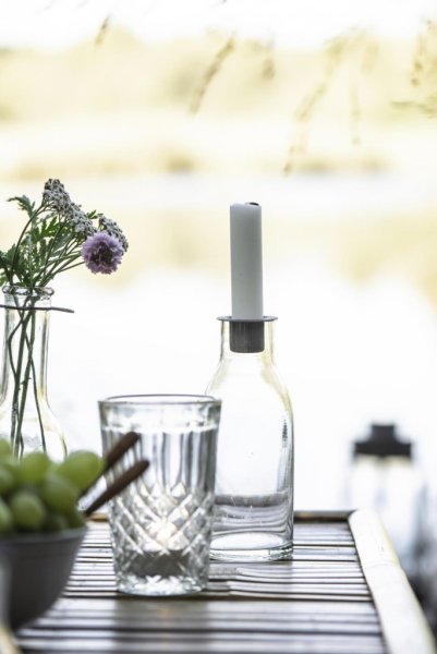 Vacker och praktisk ljusstake i modell av en flaska i genomskinligt glas. I flaskans hals finne en hållare i zink för ljuset. Hå