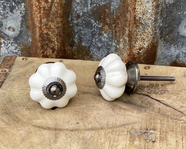 Vacker vit porslins knopp i klassisk modell med lätt veckad mönster runt om. Med en metall stomme och krage som går i en nyans