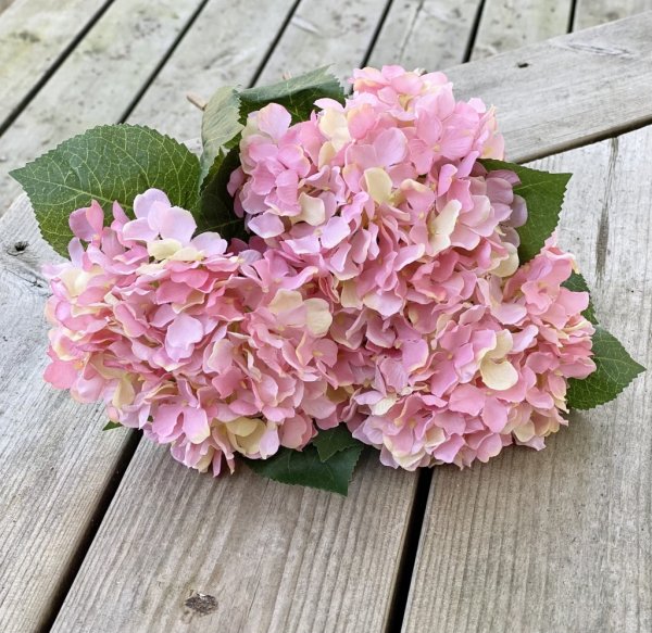 Hortensia i lila nyanser och gröna blad. Välarbetad och verklighetstrogen konstblomma. I kvist/gren modell om en blomma omgiven