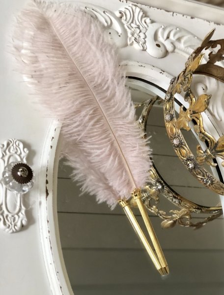 Vacker och elegant strutsfjäderpenna med Rosa fjäder och guldfärgad penna. Dekorerad med en kungakrona mellan fjäder och penna