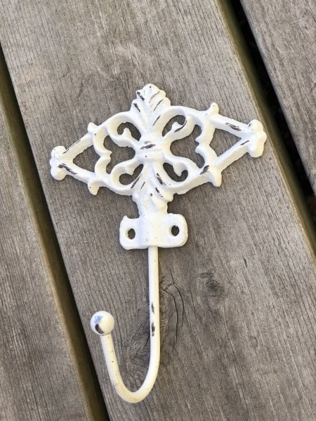 Vacker järn krok med dekorerad rygg. Vitmålad med fabriks slitna nötta detaljer i ruffigt brun/svart. Från Chic Antique Höjd: 1