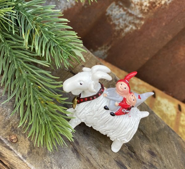 Tomtar små söta nissar som rider på en vit jul bock. Söt och detaljrik i gammeldags lantlig stil att dekorera med. Välarbetad i