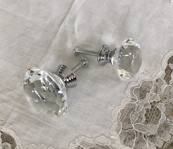 Vacker glasknopp i diamant liknande utformning med vackra slipade kanter. I mindre modell med silverfärgad metall stomme