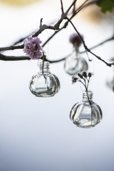 Liten söt vas i glas. Med metall ögla upptill så vasen kan hänga. Dekorerad runt om med vackert dekor mönster i glaset. För blom